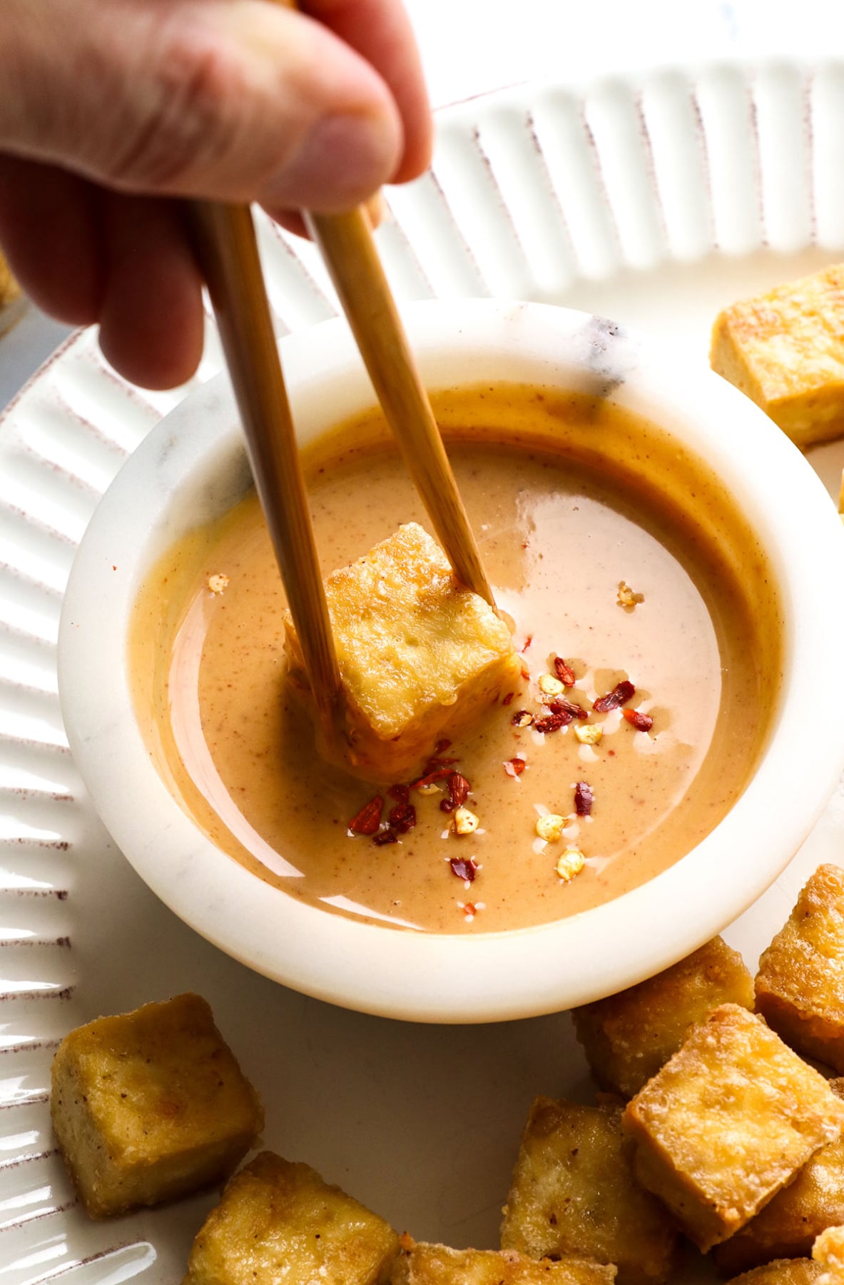 baked tofu dipped into peanut sauce.