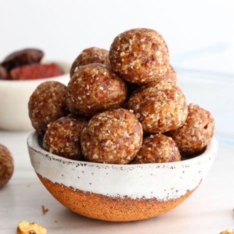 date balls stacked in a ceramic bowl.