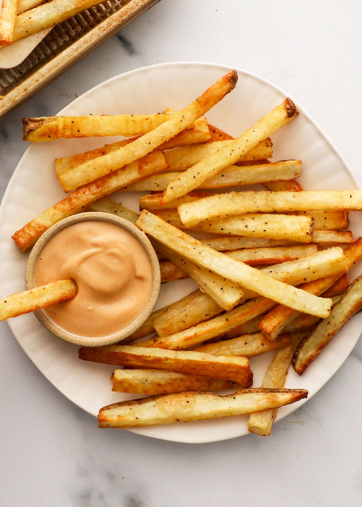 homemade fries served on a white plate with special sauce.