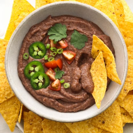 black bean dip served in a bowl with tortilla chips.