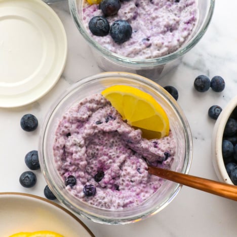 blueberry chia pudding in two jars topped with lemon slices.