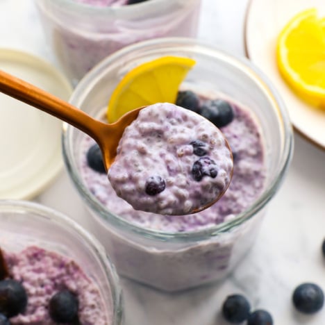 blueberry chia pudding lifted on a spoon over the jar.