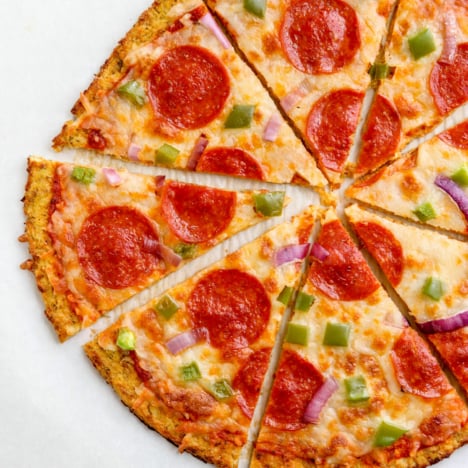 best cauliflower pizza crust recipe sliced into pieces.