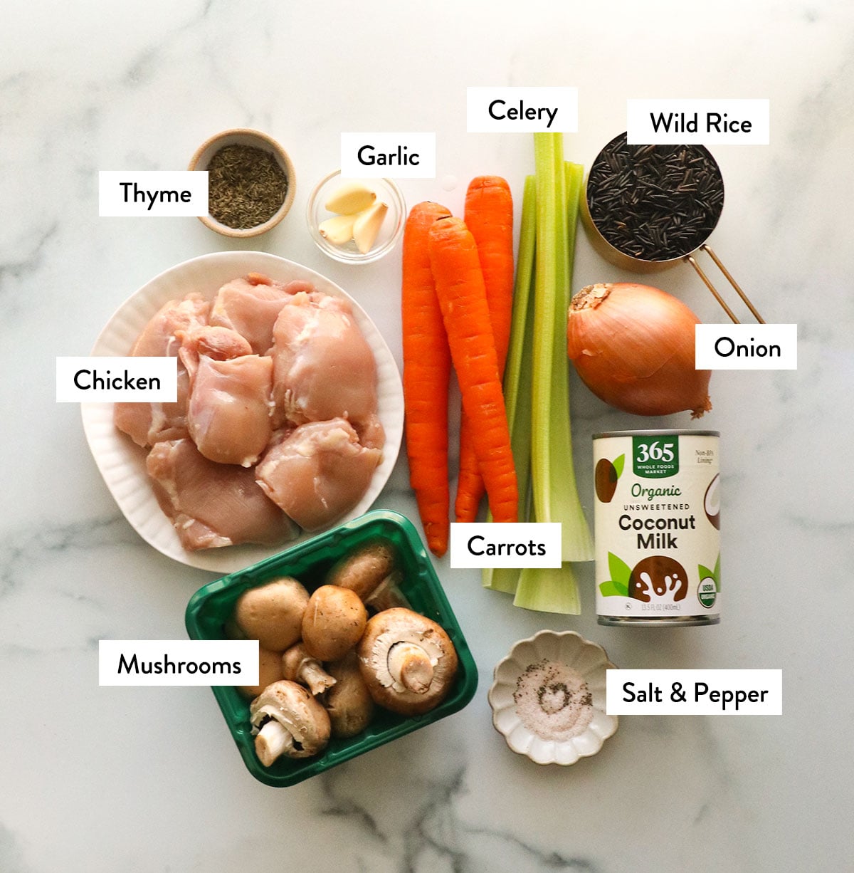 chicken thighs, carrots, celery, onion, mushrooms, and coconut milk labeled on a white surface.