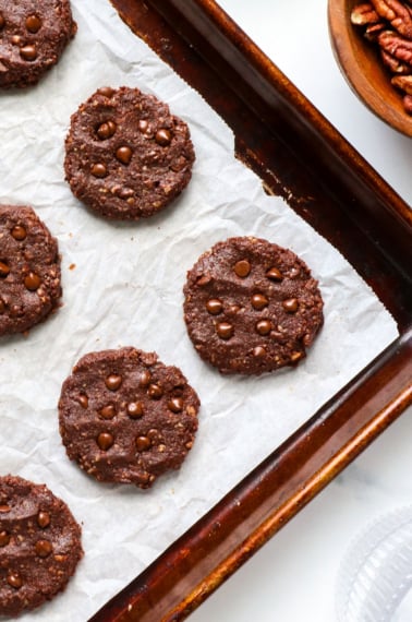 healthy chocolate cookies cooling on a sheet pan.