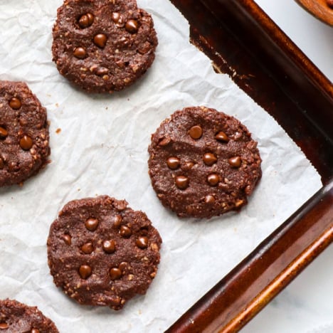healthy chocolate cookies cooling on a sheet pan.