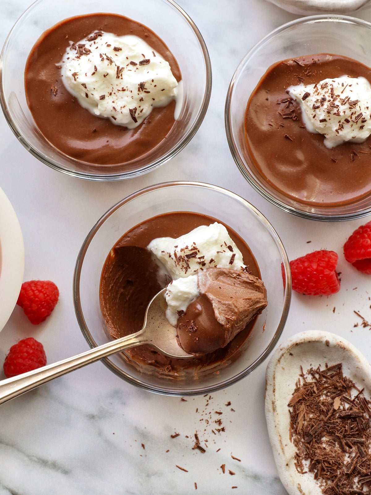 dairy-free chocolate pots de creme served in glass jars with a spoon.
