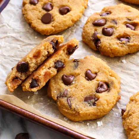 coconut flour cookies on a pan with one split in half to show texture.
