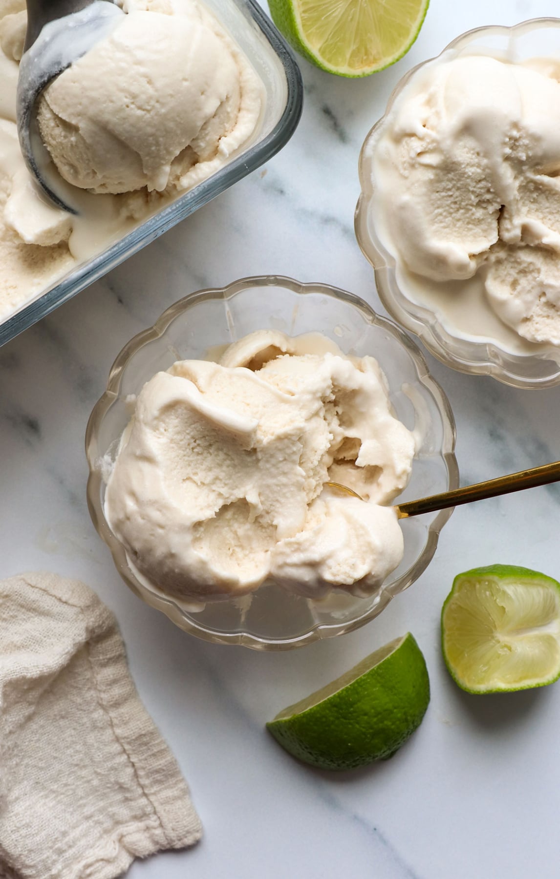 coconut milk ice cream in bowls with limes nearby.