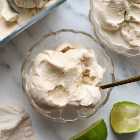 coconut milk ice cream in bowls with limes nearby.