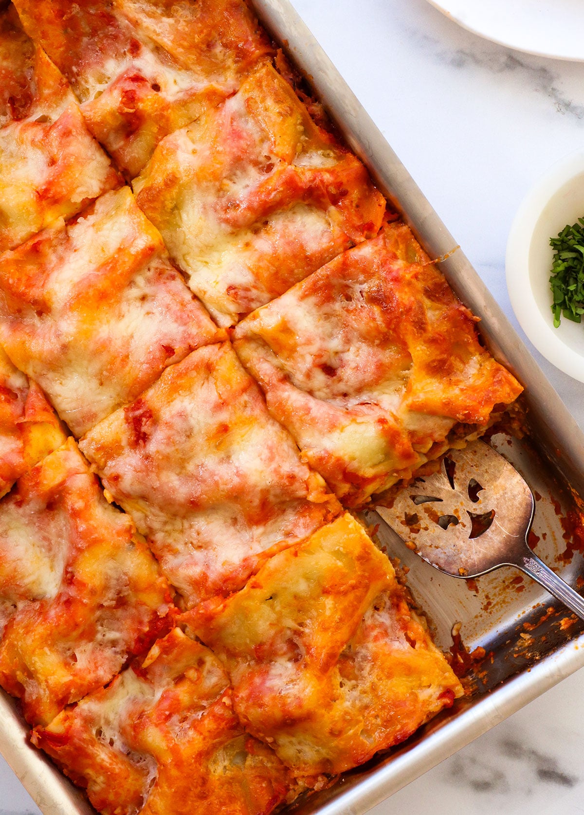 cottage cheese lasagna sliced in a pan into 12 squares.