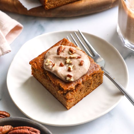 gluten-free pumpkin bar on a white plate with maple pecan glaze on top.
