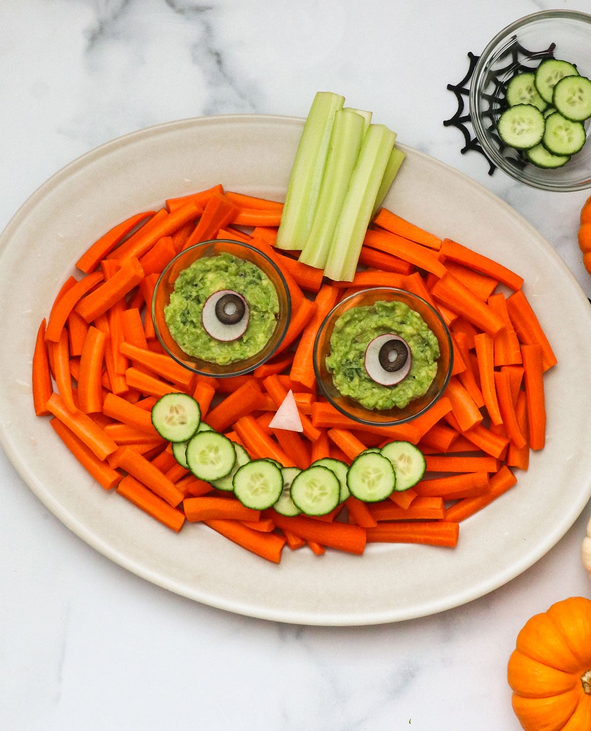 pumpkin-shaped veggie tray with a cucumber mouth and guacamole dip for eyeballs.
