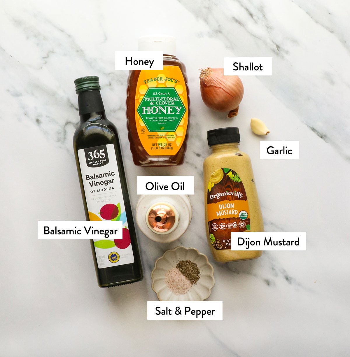 olive oil, balsamic vinegar, honey, shallot, and garlic labeled on a surface.
