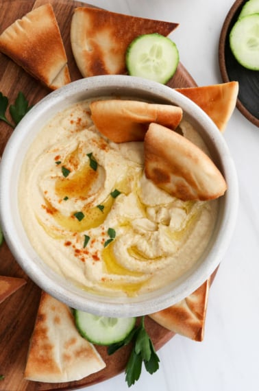 homemade hummus served with toasted pita bread and olive oil on top.