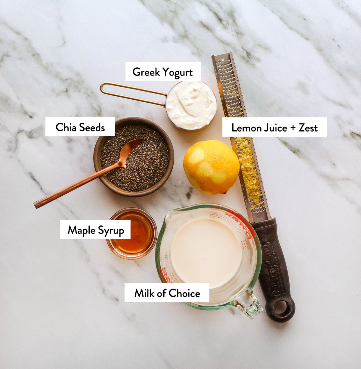 lemon, chia seeds, milk, maple syrup, and yogurt labeled in bowls.