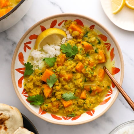 lentil and sweet potato curry served over rice with a lemon and cilantro.