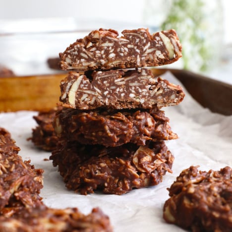 paleo no bake cookies stacked on a pan.