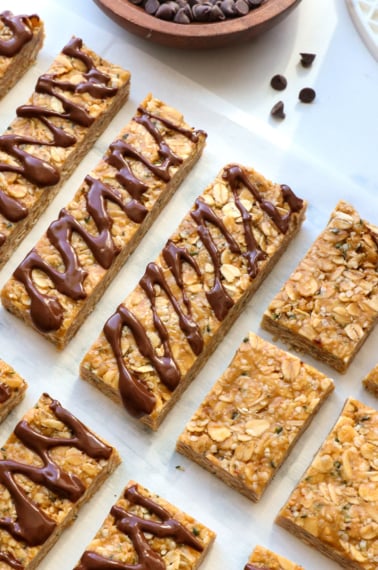 homemade granola bars sliced and topped with melted chocolate.