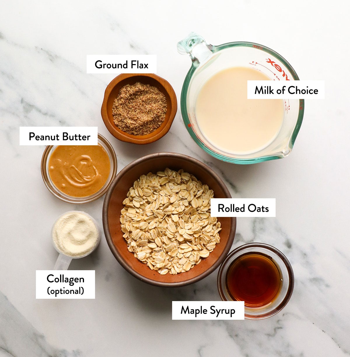 rolled oats, milk, peanut butter, flax, and maple syrup labeled in bowls.