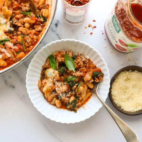 pizza beans with ground turkey sausage served in a white bowl.