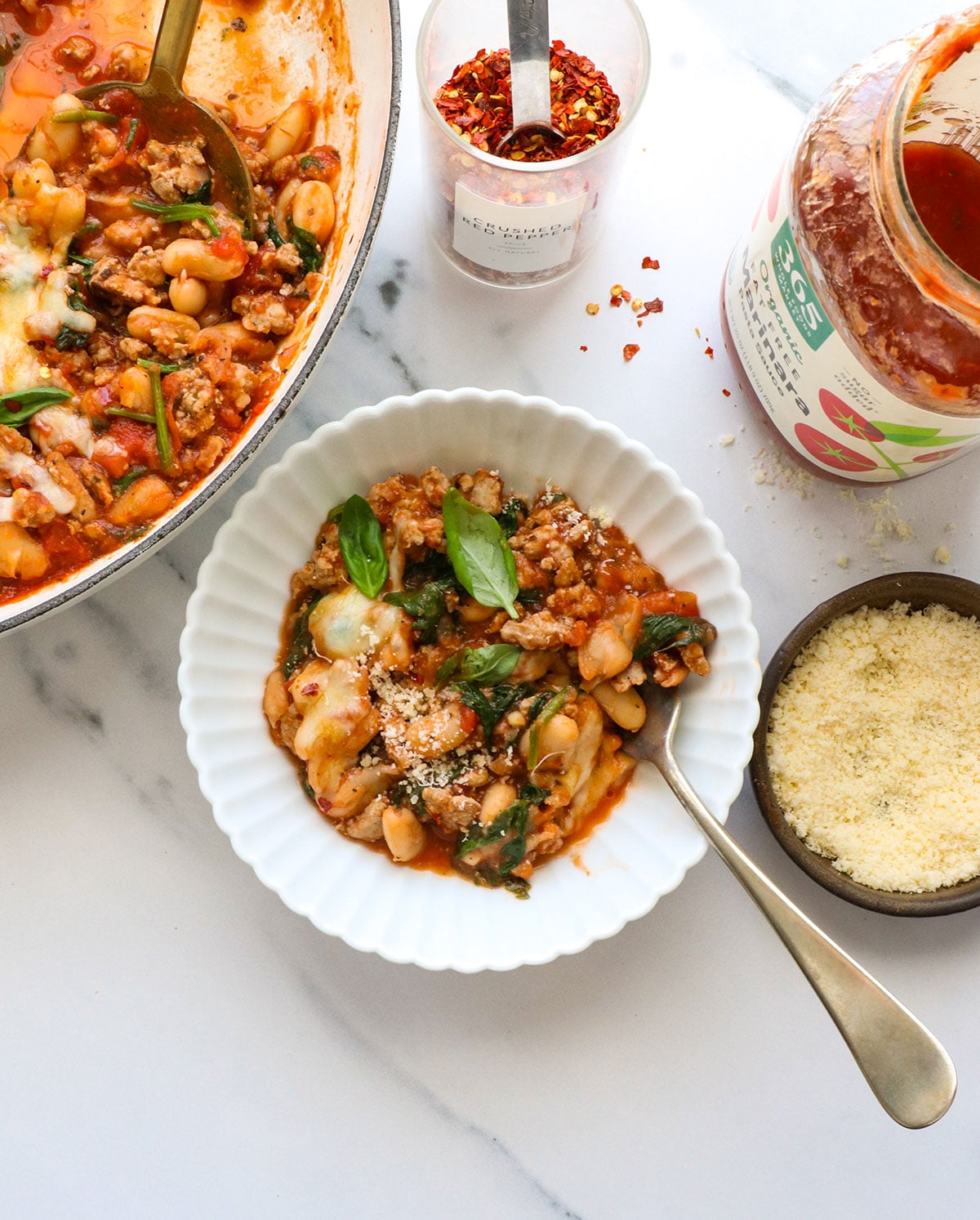 pizza beans with ground turkey sausage served in a white bowl.