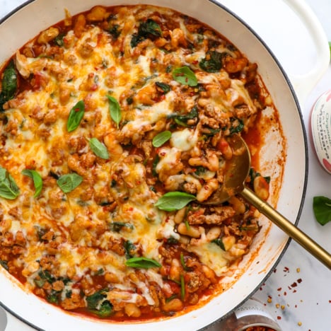 pizza beans with ground turkey served in a skillet with fresh basil.