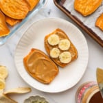 sweet potato toast on a white plate with banana slices on top.