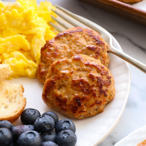healthy turkey sausage on a plate with berries and eggs.