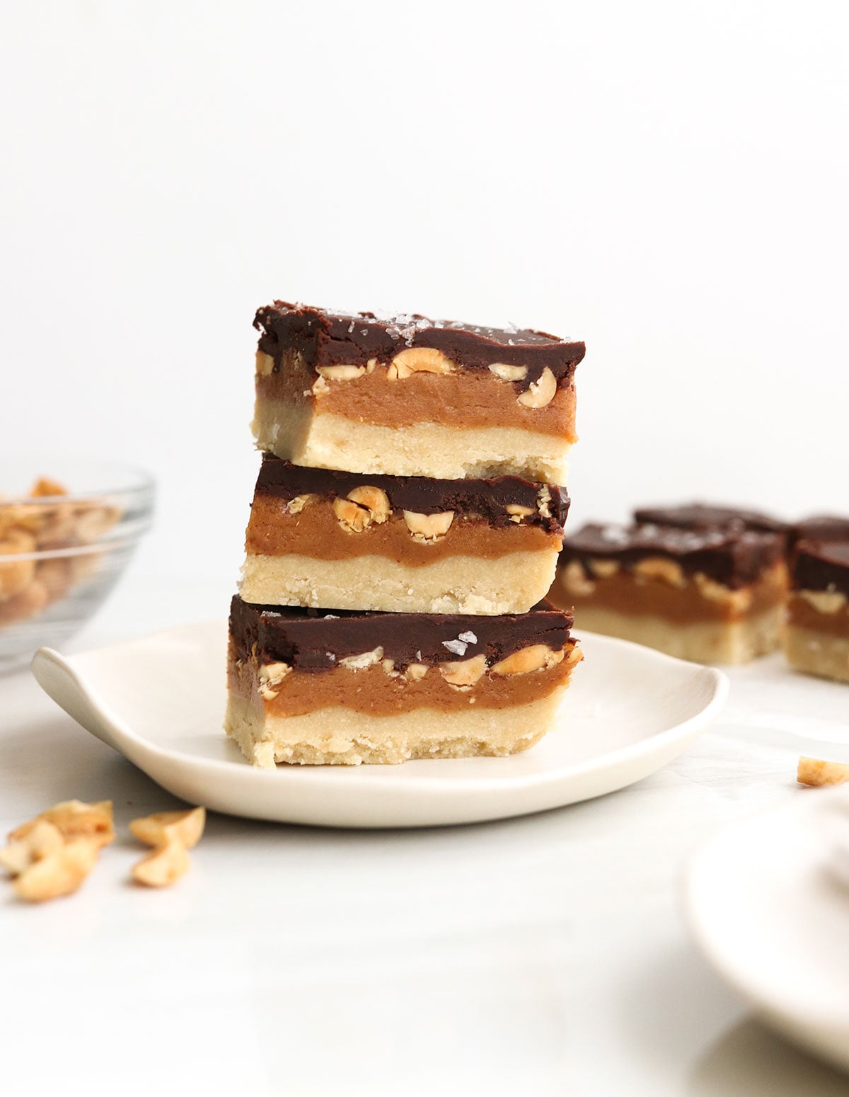 vegan snickers bars stacked on white plate.