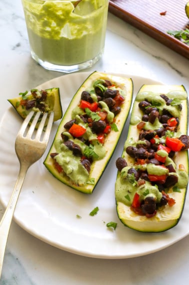 stuffed zucchini with black beans and a dairy-free cilantro sauce.