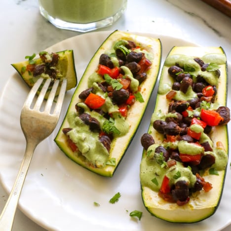 stuffed zucchini with black beans and a dairy-free cilantro sauce.